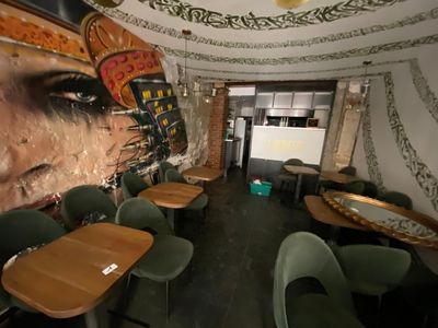 many tables and chairs in a room with a mural on the wall