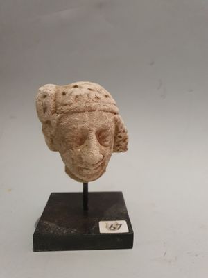 Tête de servante en stuc à la coiffure dans un serre-tête