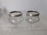 two empty glass jars sitting on a shelf next to each other