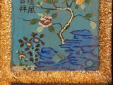 two paintings of flowers are hanging on a wall in a gold frame
