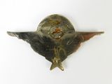 a silver brooch with a star on it on a white surface