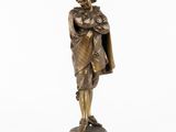 une figurine en bronze représentant un homme tenant un enfant dans ses bras