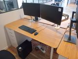 two computer monitors sitting on a desk in an office