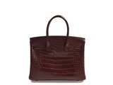 an image of a brown crocodile skin handbag on a white background
