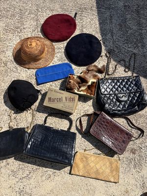 de nombreux sacs à main et chapeaux étalés par terre