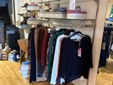 a lot of clothes hanging on a rack in a store