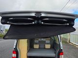 the back of a van with a surfboard in the trunk