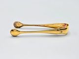 a gold spoon and spoon rest on a white surface