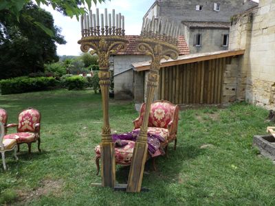 four chairs in the yard with a candelab in the background