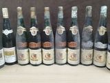 many bottles of wine that are lined up on a table