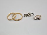 deux alliances en or et une bague en diamant posées sur une surface blanche