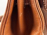 the inside of a brown leather purse with a brown handle