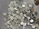 a pile of coins sitting on a table next to a pair of scissors