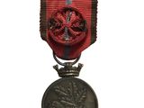an old medal with a red ribbon on a white background