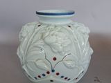 un vase blanc orné de motifs rouges et bleus