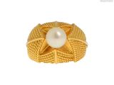 une image représentant une bague en or ornée d'une perle au centre