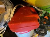 a red container sitting on top of a pile of tools
