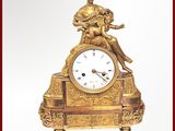 une horloge en or avec une femme assise dessus