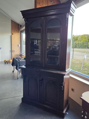 a black china cabinet in the middle of a room
