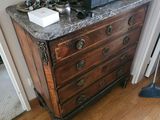 une commode en bois avec un plateau en marbre dans une chambre
