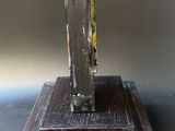 a metal object on a wooden stand on a table