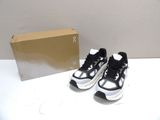 pair of black and white sneakers sitting on top of a table next to a box