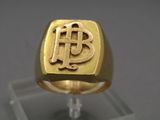 a gold ring with a monogram on the front of it