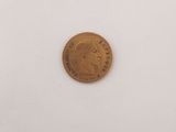 une pièce de monnaie posée sur une assiette blanche, sur une table
