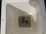 a white toilet with a drain in the middle of it