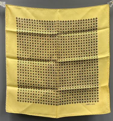 un mouchoir jaune à pois noirs suspendu à une corde à linge