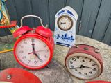 three clocks sitting on a table next to each other