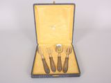 three forks and spoons in a case on a table