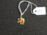 a small gold elephant with a red heart on it ' s back