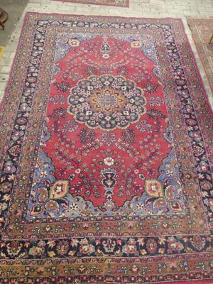 an oriental rug on display in a room with a table and chairs