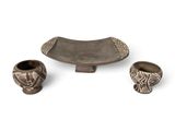 three pieces of pottery sitting on top of a table next to each other