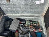 une boîte métallique posée par terre et remplie d'outils divers