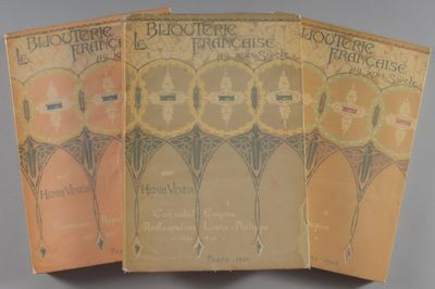 trois livres sont empilés sur une table
