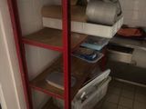 a red shelf in the corner of a room