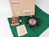a box with a clock and other items on a green cloth