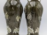 two vases sitting side by side on a white surface