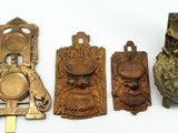 quatre heurtoirs de porte en laiton ancien sont alignés sur une surface blanche