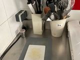 Il y a de nombreux ustensiles de cuisine sur le plan de travail de cette cuisine