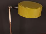 a close up of a yellow table lamp on a wooden table