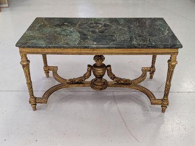une table au plateau en marbre posée sur un sol blanc