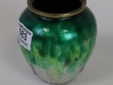a green vase sitting on a table with a price tag on it