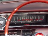 dashboard of a classic car with a red steering wheel and gauges
