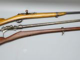 trois types d'armes à feu sont exposés sur une surface blanche