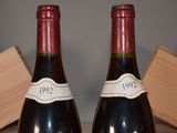 two bottles of wine sitting next to each other on a table