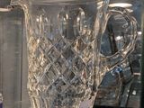 un pichet en verre posé sur une étagère en verre