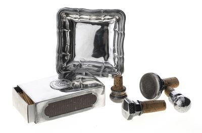une plaque en argent sur laquelle est fixé un miroir, à côté d'une paire de boutons en bois